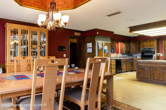 dining area featuring light carpet, sink, a textured ceiling, and a notable chandelier