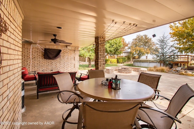 view of patio / terrace with ceiling fan and a fire pit