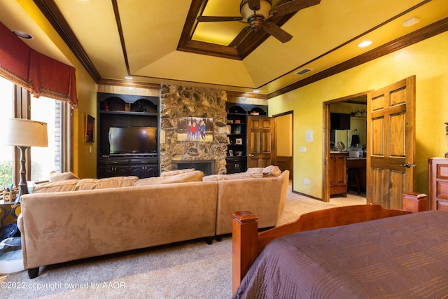 bedroom with ensuite bathroom, a stone fireplace, ornamental molding, light colored carpet, and a tray ceiling