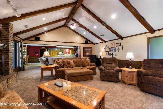 living room with ceiling fan, vaulted ceiling with beams, carpet, a fireplace, and a textured ceiling