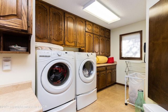 clothes washing area with cabinets and washer and dryer