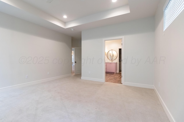 8303 City View Dr, Amarillo, TX 79118 - unfurnished bedroom with light colored carpet, baseboards, recessed lighting, ensuite bath, and a tray ceiling