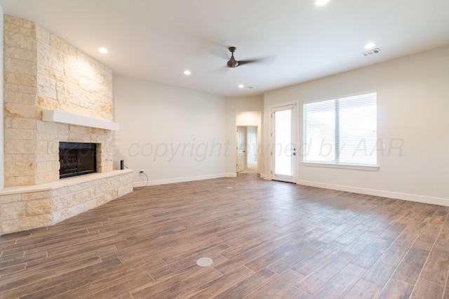 8303 City View Dr, Amarillo, TX 79118 - unfurnished living room featuring a ceiling fan, a stone fireplace, wood finished floors, baseboards, and recessed lighting