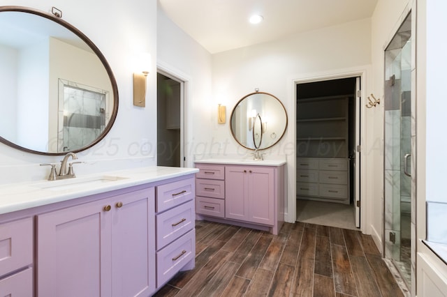 8303 City View Dr, Amarillo, TX 79118 - bathroom with wood finished floors, a stall shower, two vanities, and recessed lighting