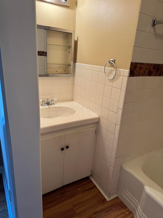 811 S Palo Duro St, Amarillo, TX 79106 - bathroom with tile walls, vanity, wood finished floors, and a tub to relax in