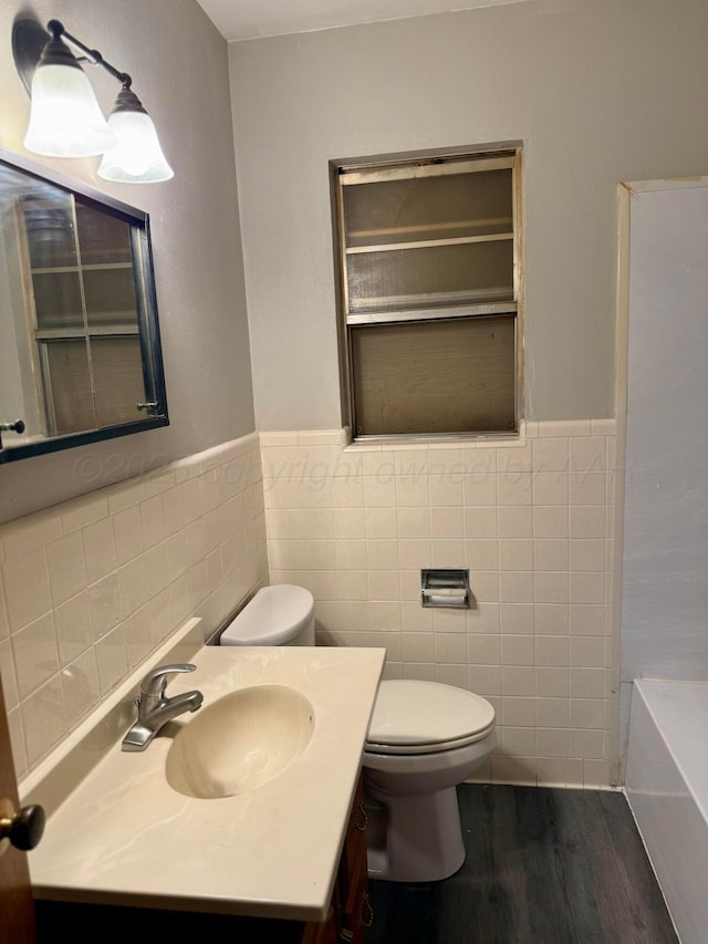 408 Jupiter St, Pampa, TX 79065 - bathroom with tile walls, wood finished floors, toilet, vanity, and a bath