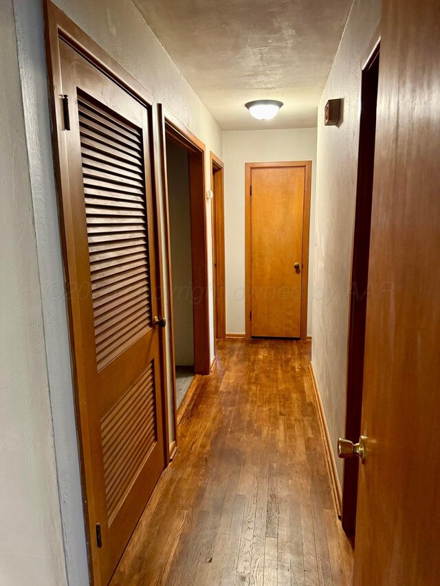 408 Jupiter St, Pampa, TX 79065 - hallway with hardwood / wood-style flooring, a textured wall, and baseboards
