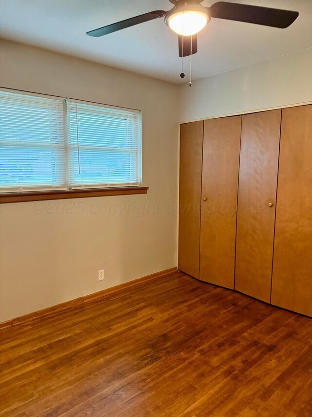 408 Jupiter St, Pampa, TX 79065 - unfurnished bedroom featuring multiple windows, wood finished floors, a closet, and a ceiling fan
