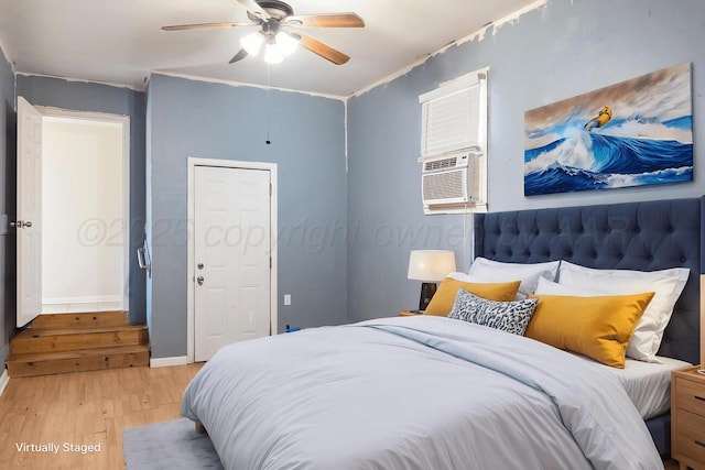 bedroom featuring light wood-style flooring, ceiling fan, baseboards, cooling unit, and ornamental molding