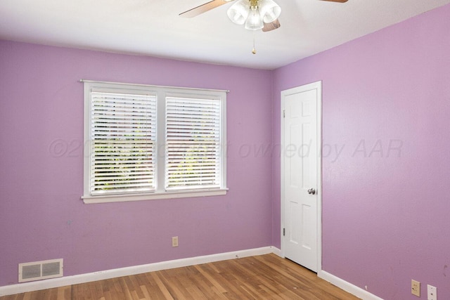 empty room featuring a ceiling fan, baseboards, and light wood-type flooring