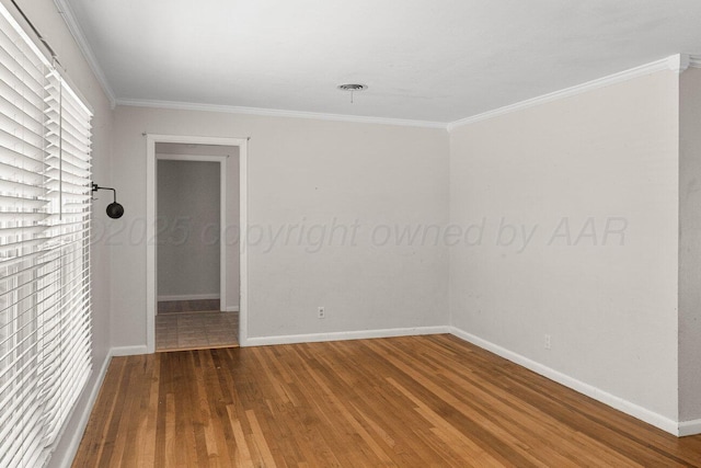 unfurnished room featuring wood finished floors, crown molding, and baseboards