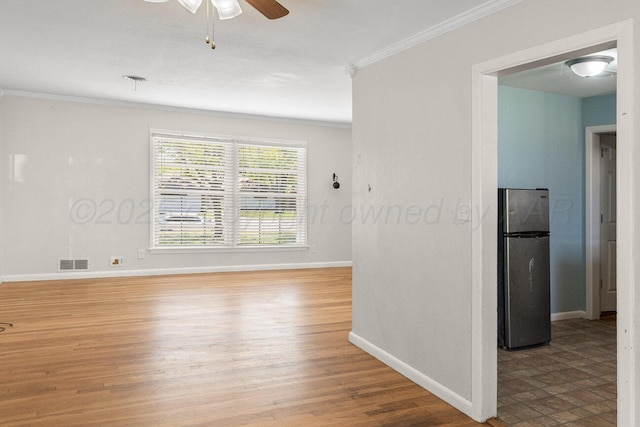 empty room featuring ornamental molding, baseboards, ceiling fan, and wood finished floors