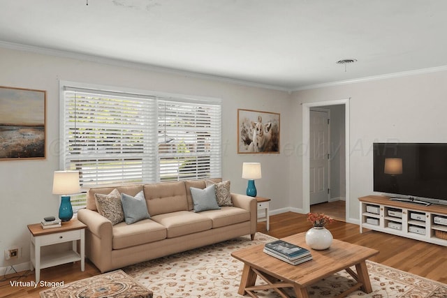 living room featuring ornamental molding, healthy amount of natural light, wood finished floors, and baseboards