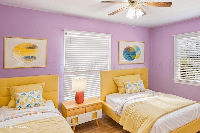 bedroom featuring multiple windows, ceiling fan, and wood finished floors