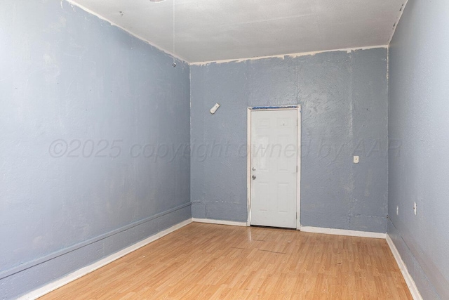 empty room featuring light wood-style floors and baseboards