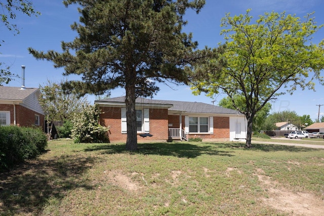 view of front facade with brick siding, a front lawn, and covered porch