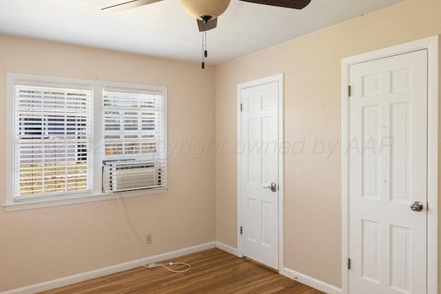 unfurnished bedroom featuring wood finished floors, baseboards, cooling unit, and ceiling fan