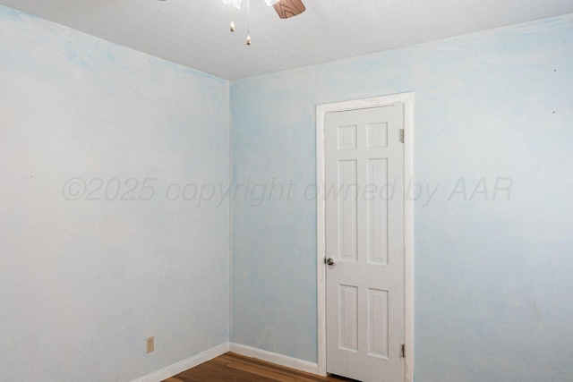 unfurnished room with ceiling fan, baseboards, and dark wood-style flooring
