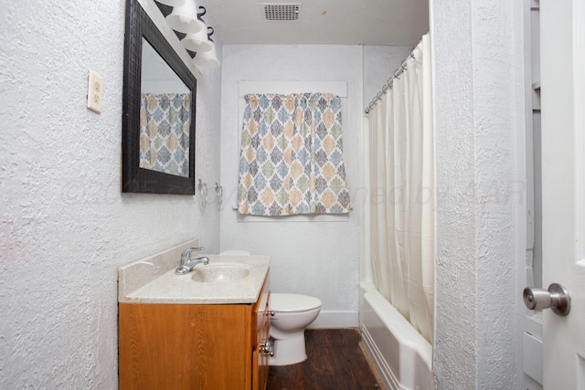 full bathroom featuring vanity, hardwood / wood-style flooring, toilet, and shower / tub combo with curtain