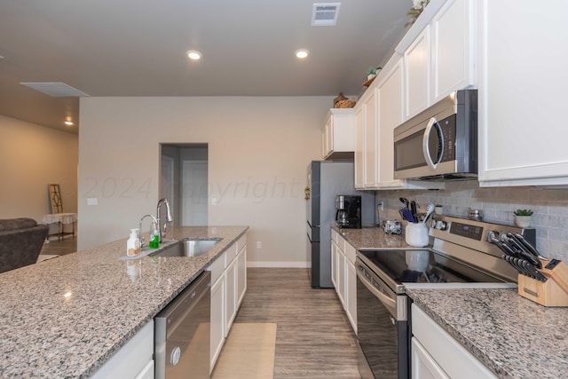 1839 Montaluse Rd, Amarillo, TX 79118 - kitchen with stainless steel appliances, white cabinetry, backsplash, light wood-type flooring, and light stone counters