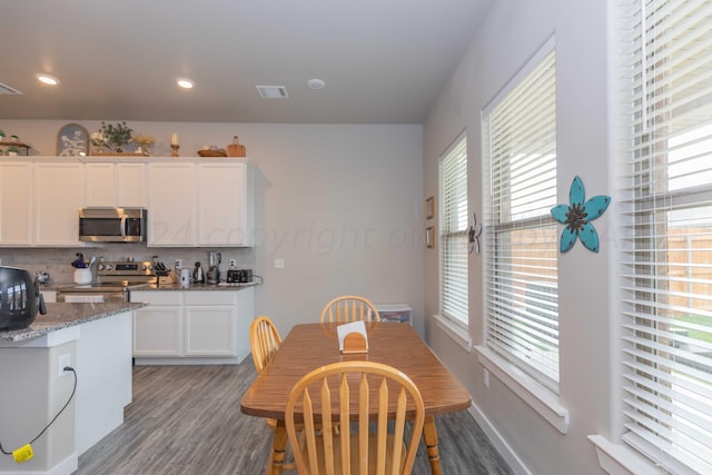 1839 Montaluse Rd, Amarillo, TX 79118 - kitchen featuring stainless steel appliances, wood finished floors, white cabinetry, decorative backsplash, and light stone counters