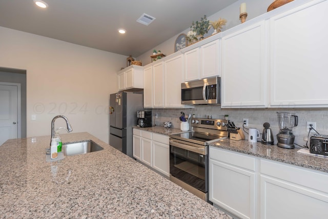 1839 Montaluse Rd, Amarillo, TX 79118 - kitchen with stainless steel appliances, white cabinetry, backsplash, light stone counters, and recessed lighting