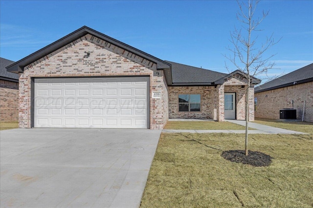 view of front facade featuring an attached garage, a front yard, concrete driveway, and brick siding