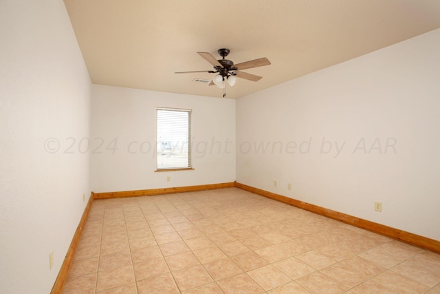 empty room with ceiling fan and light tile patterned floors