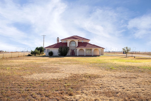 view of front facade with a front yard and a rural view