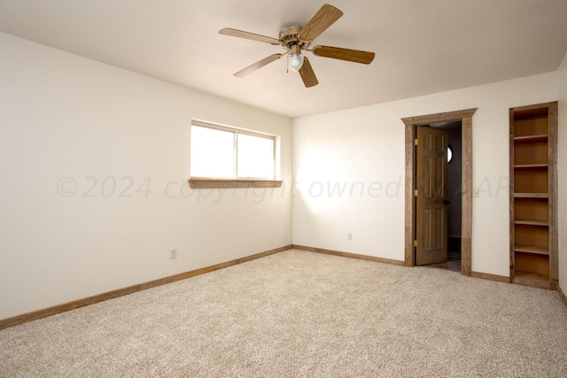 unfurnished bedroom featuring carpet, ceiling fan, and a walk in closet