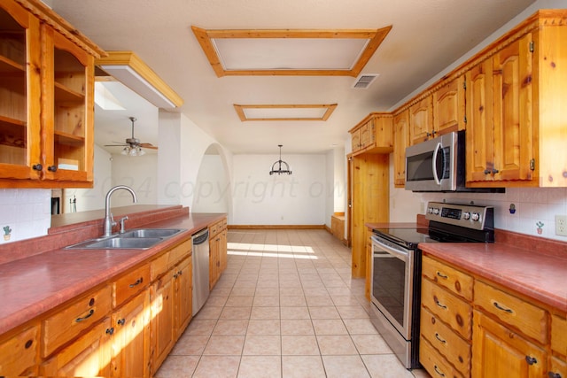 kitchen featuring sink, pendant lighting, appliances with stainless steel finishes, and decorative backsplash