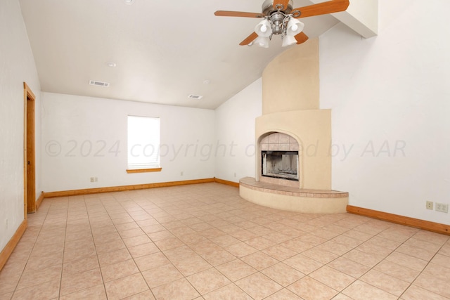 unfurnished living room with a fireplace, ceiling fan, light tile patterned floors, and lofted ceiling