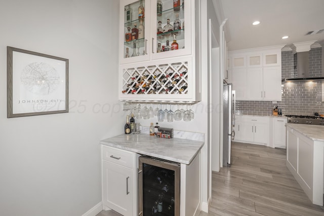 6201 Bay Rdg, Amarillo, TX 79119 - indoor dry bar with beverage cooler, wall chimney range hood, stainless steel appliances, tasteful backsplash, and recessed lighting
