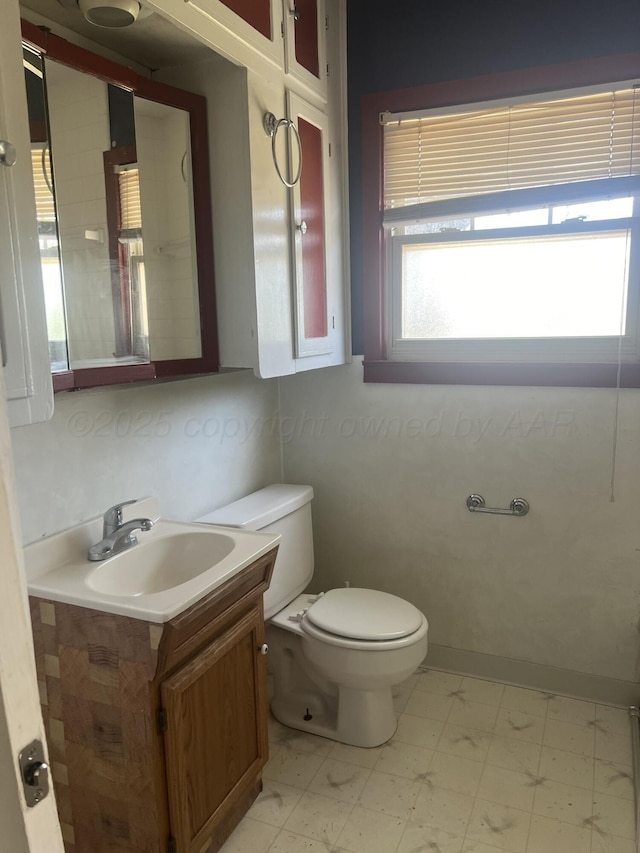 bathroom with toilet, a healthy amount of sunlight, and vanity