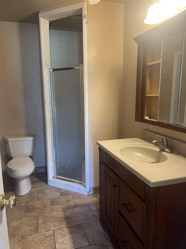 bathroom featuring toilet, walk in shower, and vanity