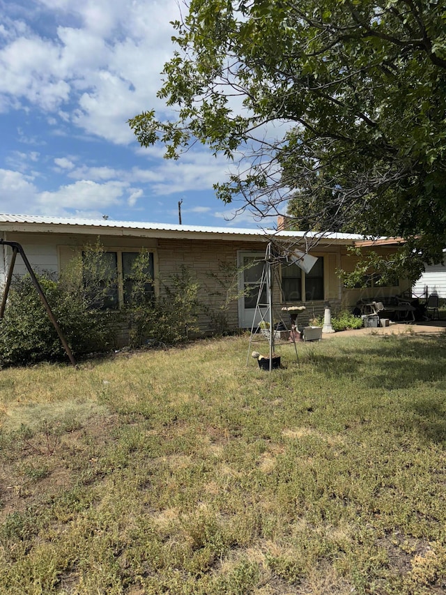 rear view of property featuring a yard