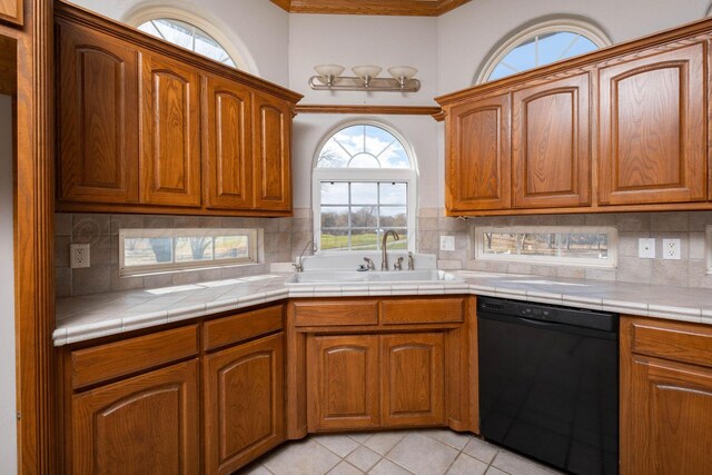 121 Quail Blvd, Amarillo, TX 79124 - kitchen with dishwasher, ornamental molding, light tile patterned floors, backsplash, and brown cabinets