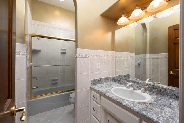 121 Quail Blvd, Amarillo, TX 79124 - bathroom with vanity, tile patterned floors, enclosed tub / shower combo, and tile walls