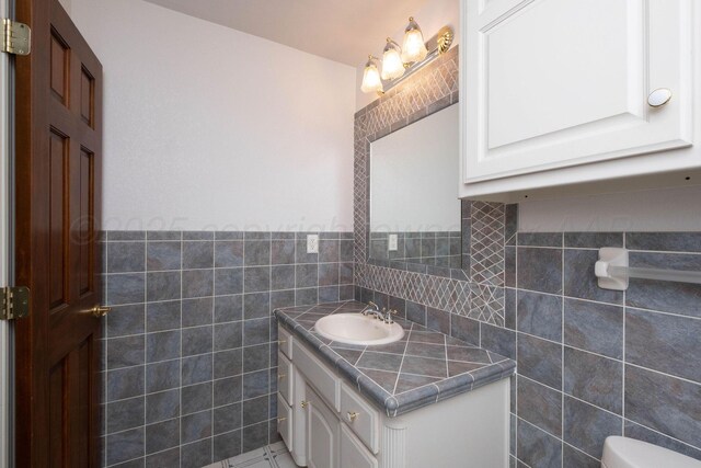 121 Quail Blvd, Amarillo, TX 79124 - half bathroom with tile walls, vanity, and a wainscoted wall