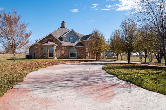 121 Quail Blvd, Amarillo, TX 79124 - view of front of property with curved driveway, brick siding, a chimney, and a front lawn