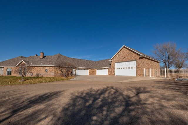 121 Quail Blvd, Amarillo, TX 79124 - view of front of home with driveway, a garage, brick siding, and a chimney