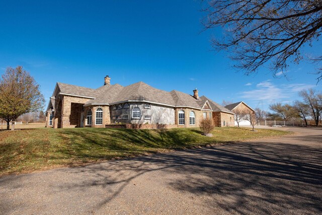 121 Quail Blvd, Amarillo, TX 79124 - view of side of home with a chimney, a lawn, brick siding, and driveway