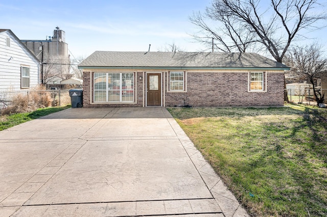 single story home featuring brick siding, a front yard, and fence