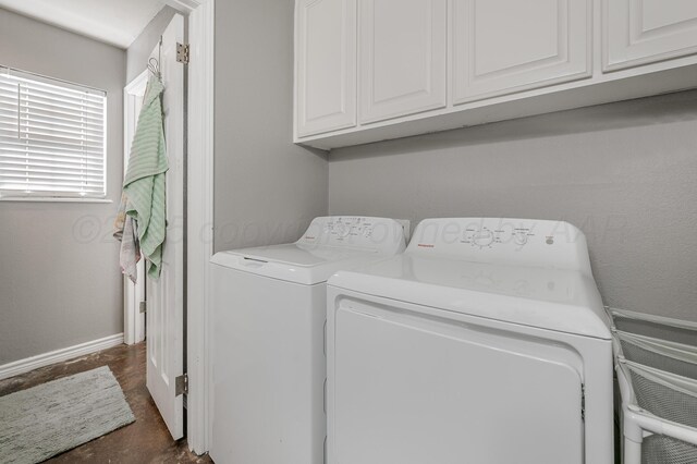 laundry room featuring baseboards, cabinet space, and separate washer and dryer