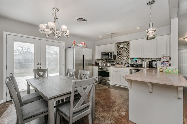 dining area with french doors, visible vents, concrete floors, and a chandelier