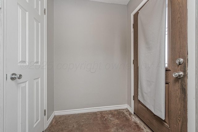 interior space featuring unfinished concrete floors and baseboards