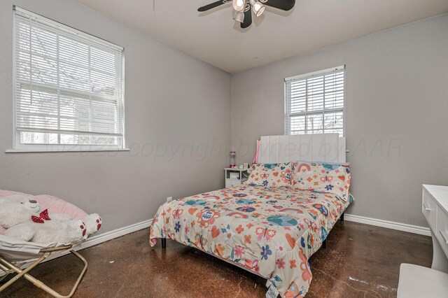 bedroom with baseboards, concrete flooring, and ceiling fan