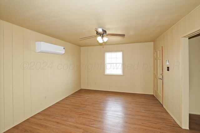 1308 Haggard St, Borger, TX 79007 - spare room featuring an AC wall unit, a ceiling fan, and light wood-style floors
