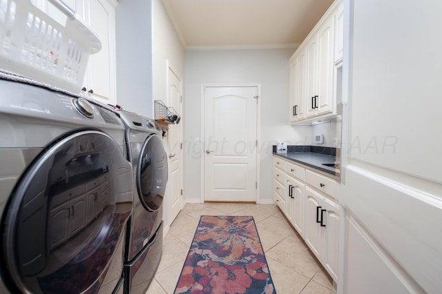 clothes washing area featuring ornamental molding, washing machine and dryer, baseboards, cabinet space, and light tile patterned floors