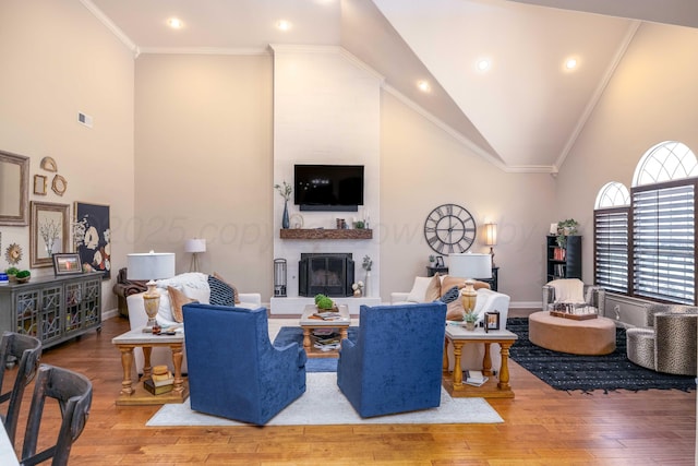 living room featuring visible vents, crown molding, wood finished floors, a fireplace, and high vaulted ceiling